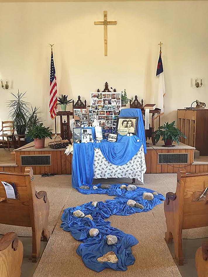 A memorial table with framed images at the front of the church