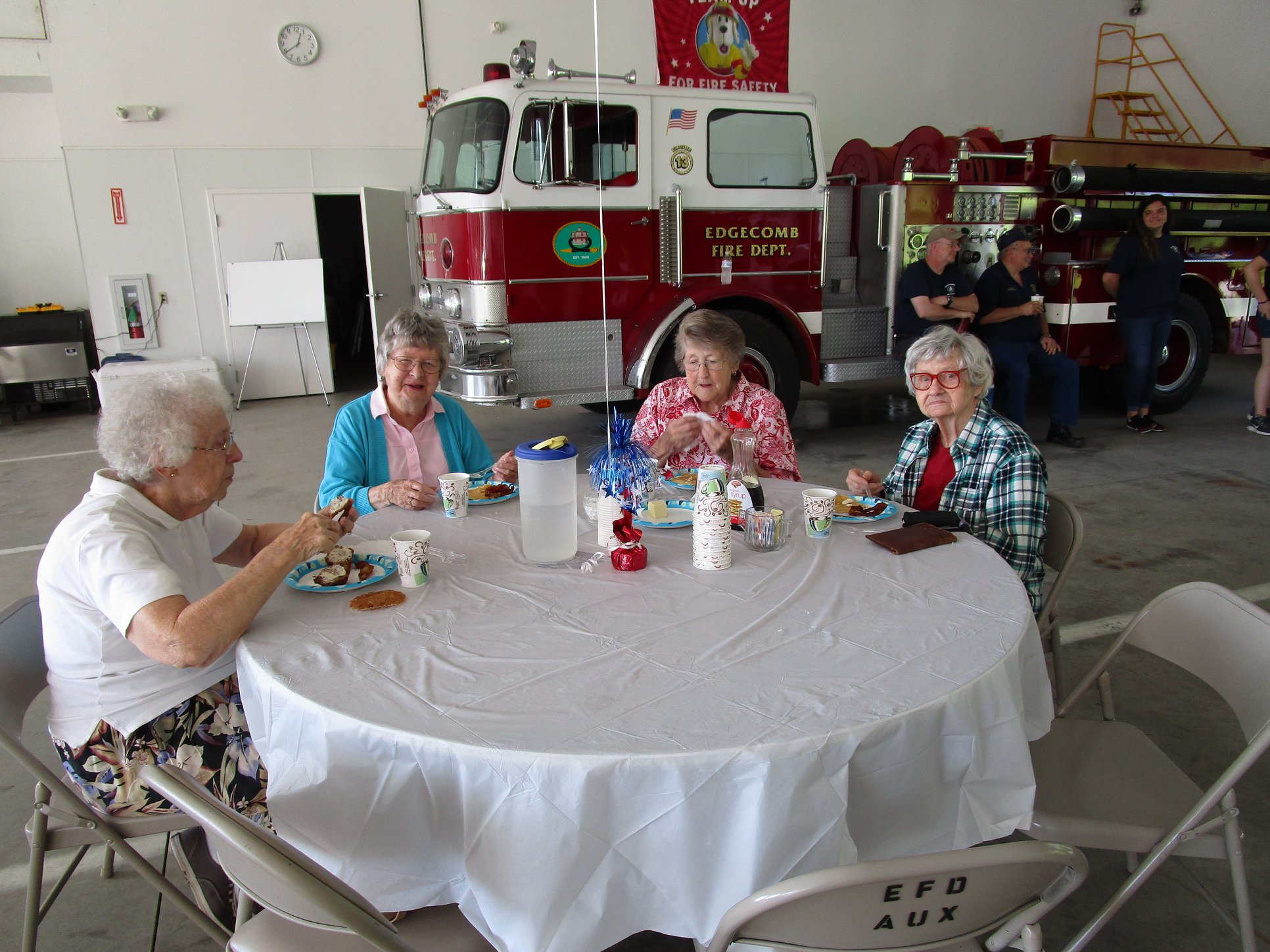 People eating around a table inside the fire department