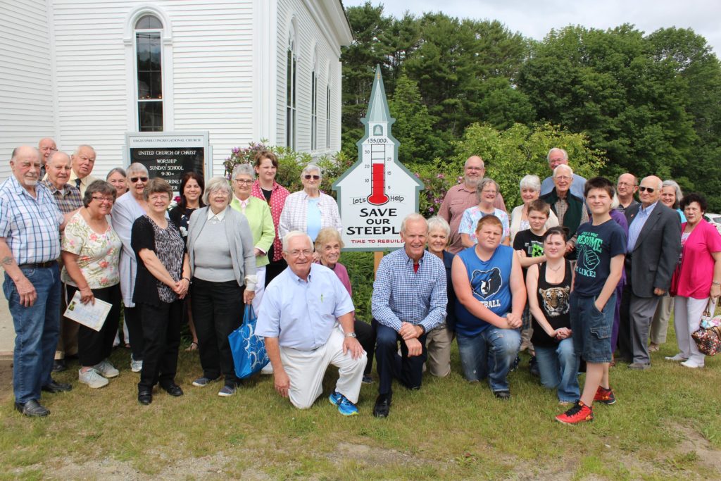 The congregation poses for a group photo in front of the church
